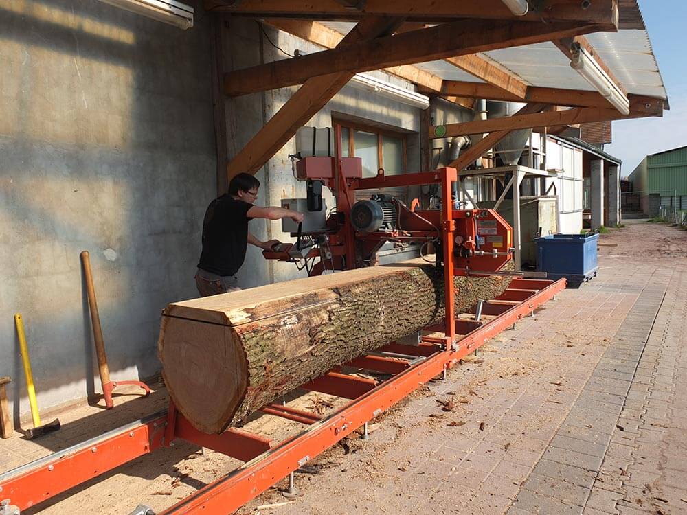 Eric Fritz en pleine séance de sciage de bois avant stockage pour votre escalier
